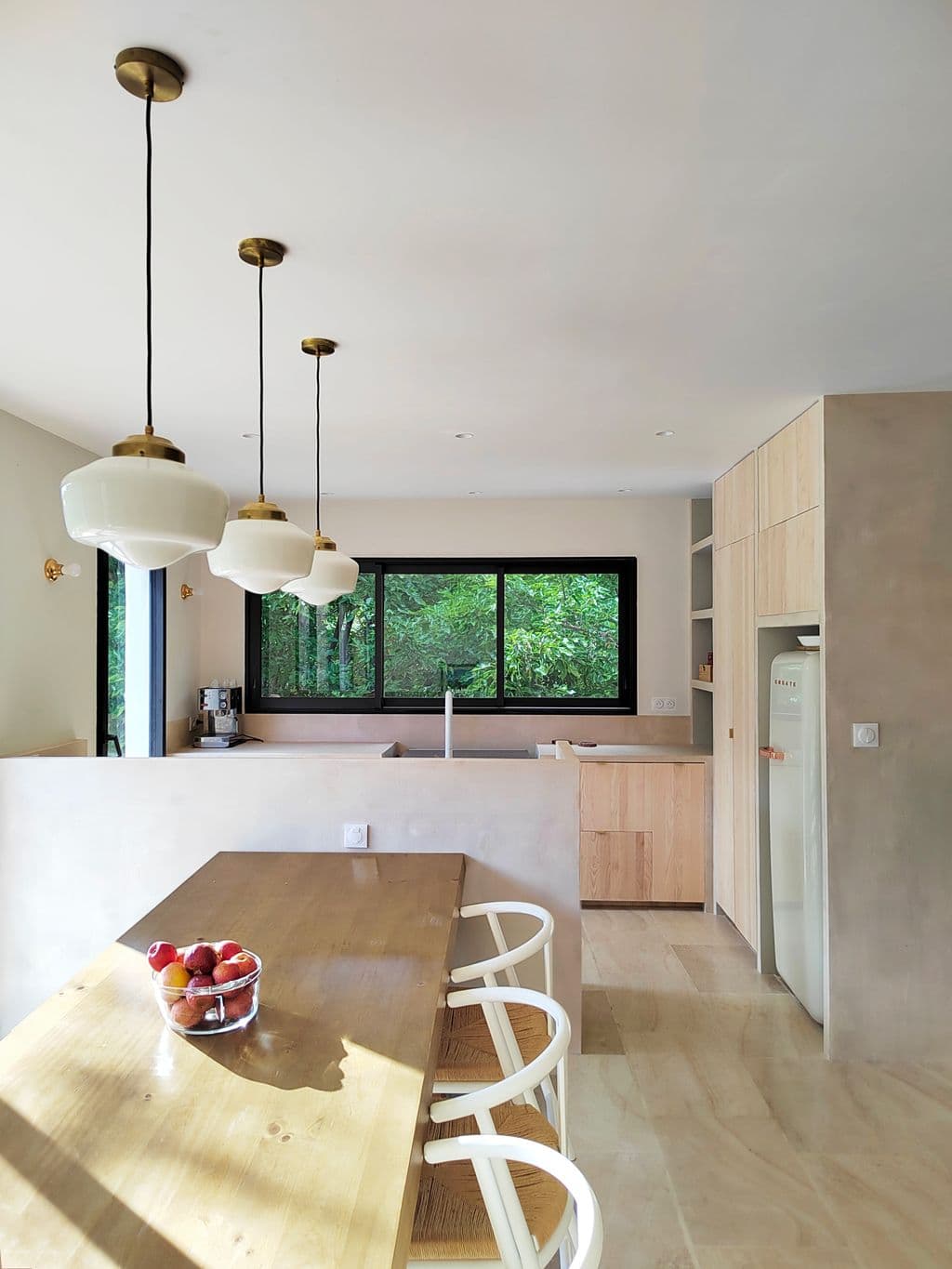 extension cuisine a eoures table en bois sol travertin et cuisine en beton resine.jpg